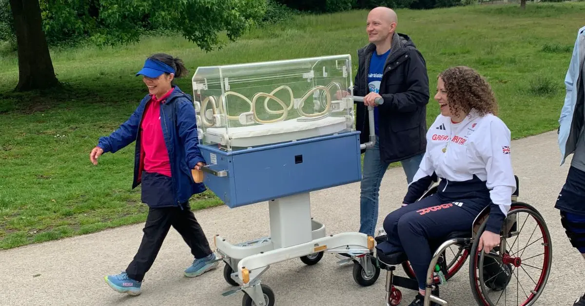 Gemma Collis next to the road-worth incubator with Ickle Pickles staff and a supporter pushing the incubator.