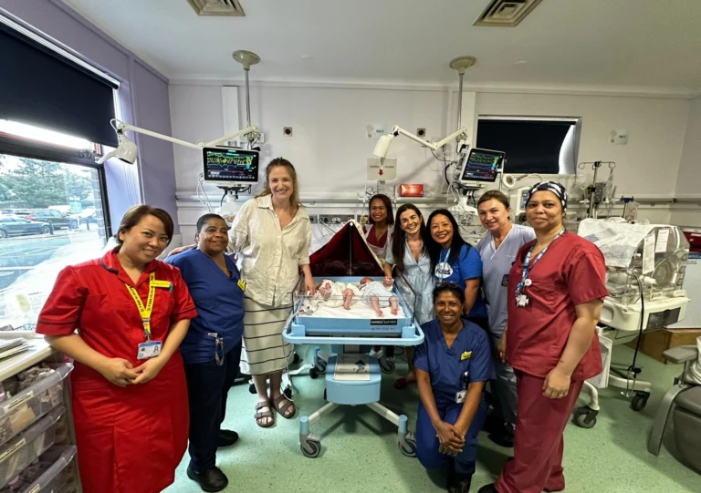 Neonatal staff with donated twin cot and a NICU family